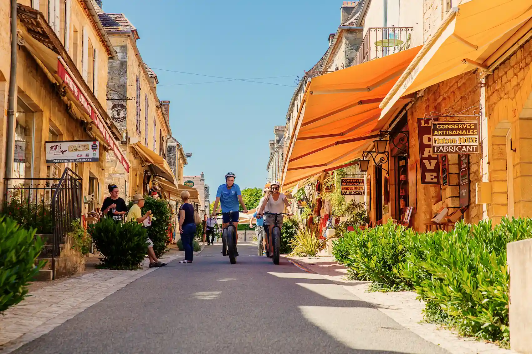 Cycling through the narrow streets of Domme Two people are riding bicycles in the alleys of Domme